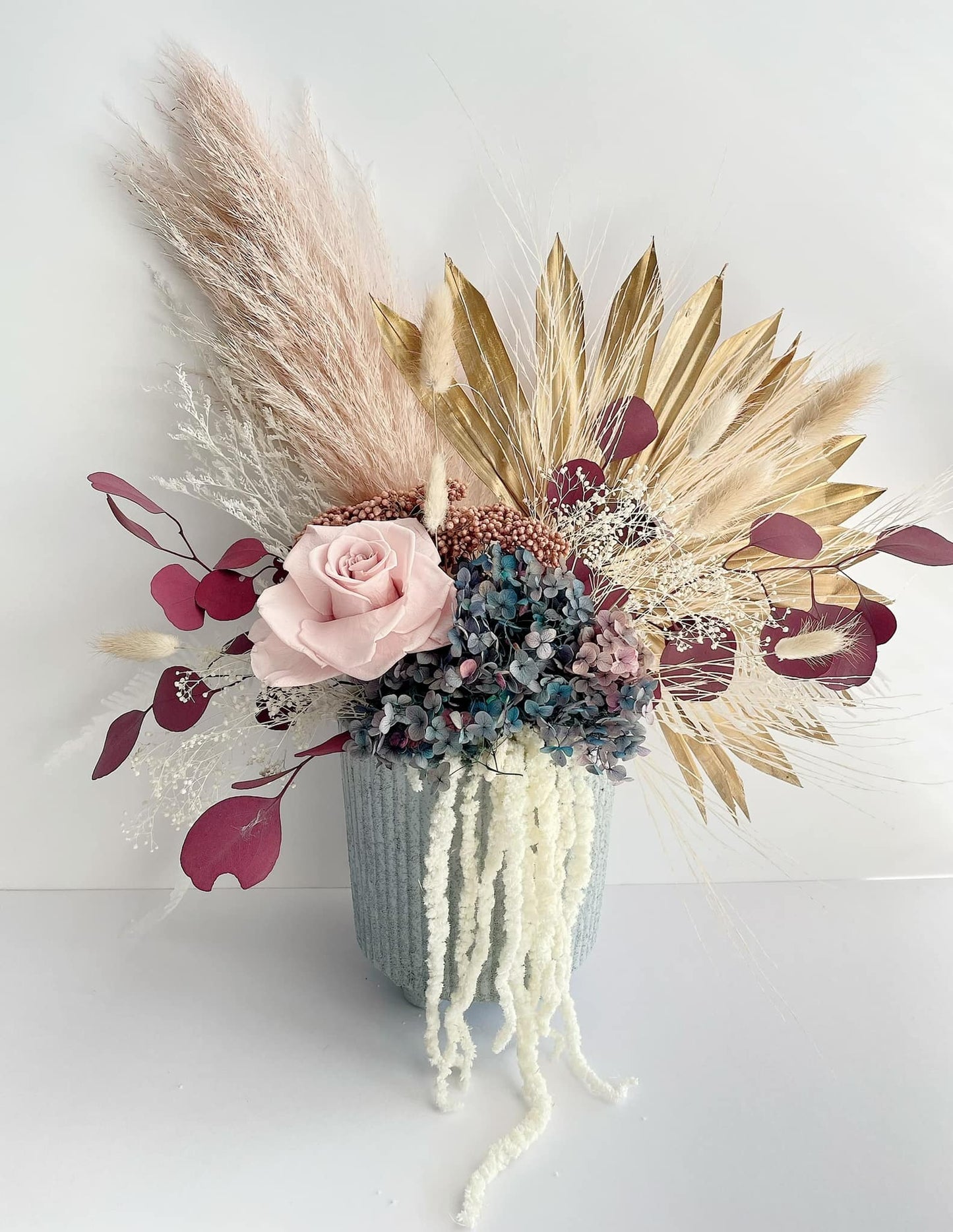 Blue and pink neutral dried flower bunch in a blue pot to keep the room brighter.